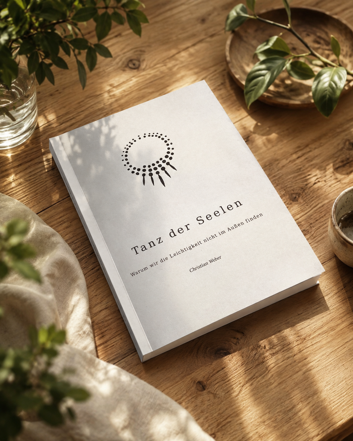 Das Buch Tanz der Seelen liegt im Sonnenlicht auf einem Holztisch.